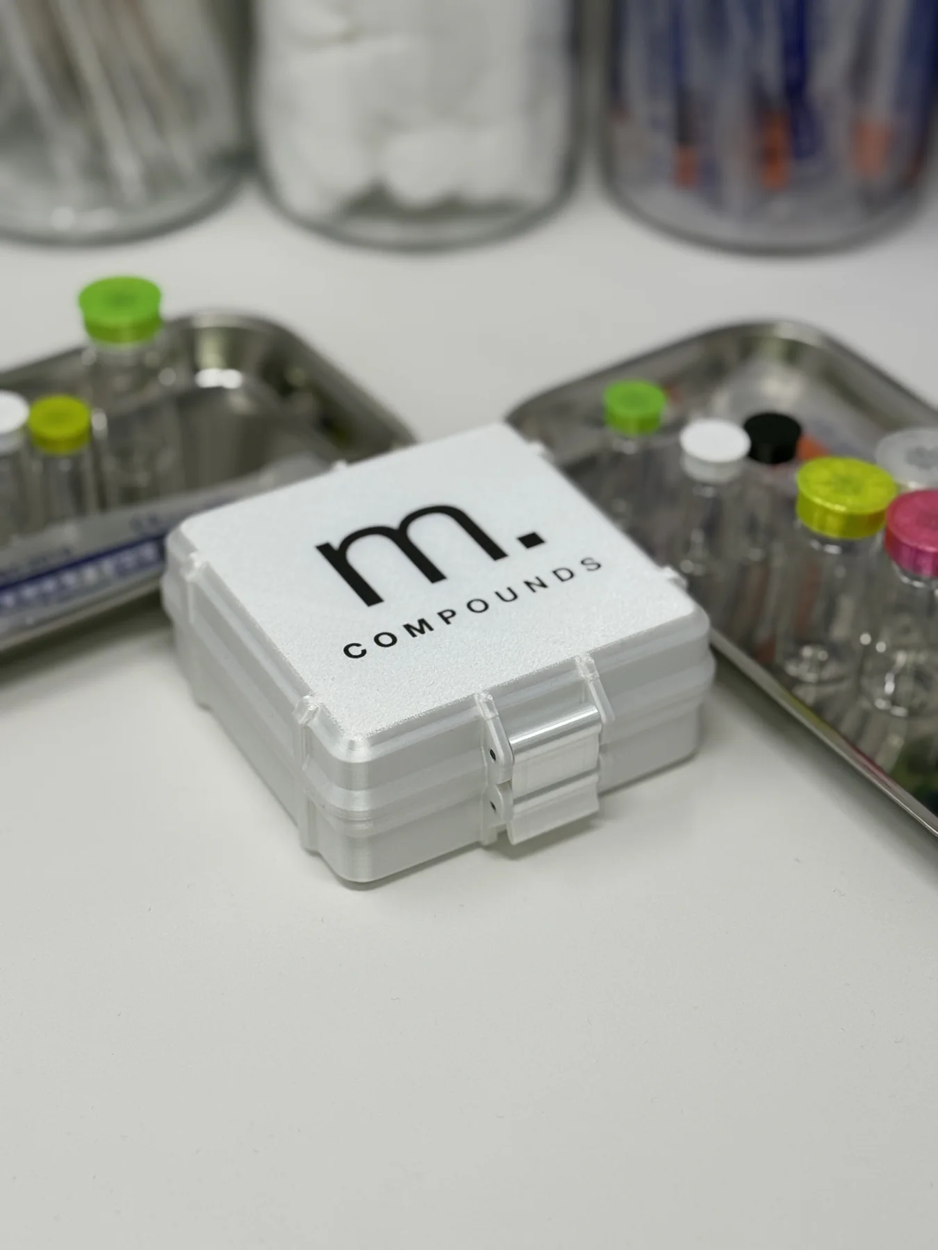 Closed white Matter Compounds twelve-vial case with black m. logo