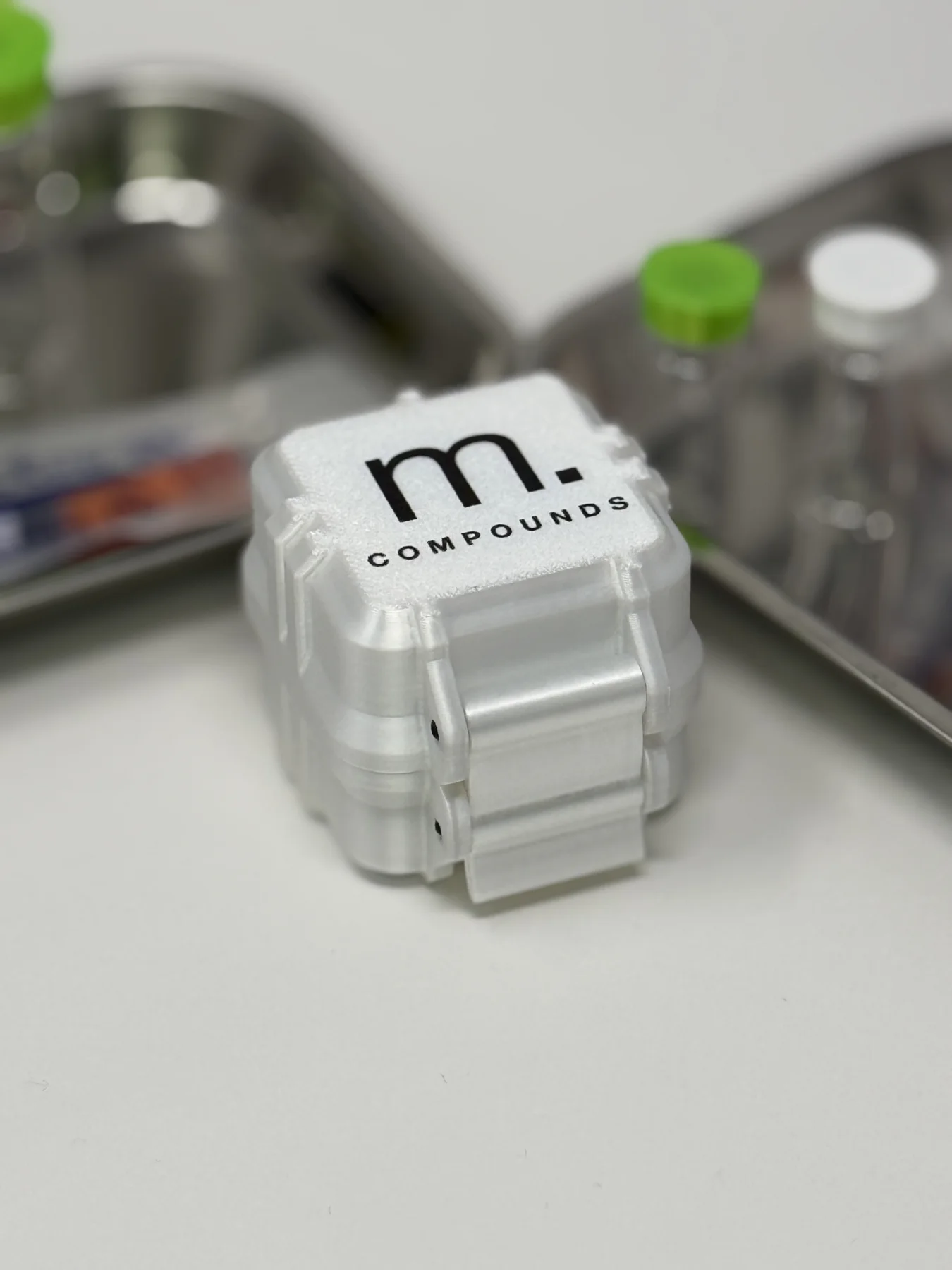 Closed white Matter Compounds four-vial case with black m. logo